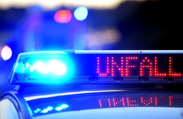 Unfallwagen stehen beschädigt auf Straße.